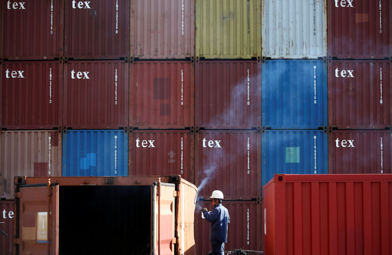 © Reuters. FILE PHOTO: A man repairs a container at an industrial port in Tokyo