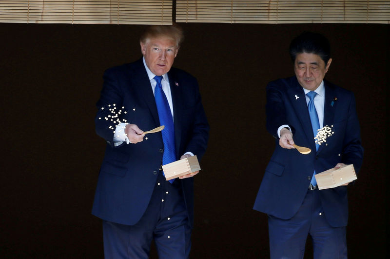 © Reuters. FILE PHOTO : U.S. President Donald Trump and Japan's Prime Minister Shinzo Abe feed carp before their working lunch at Akasaka Palace in Tokyo