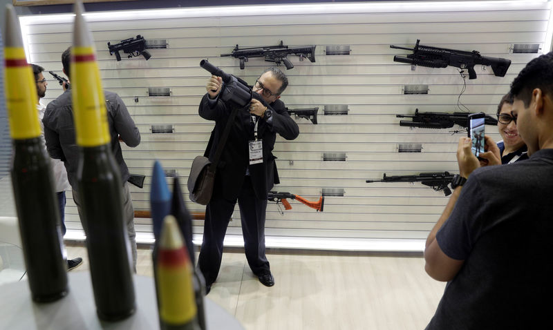 © Reuters. Homem segura arma durante feira militar LAAD, no Rio de Janeiro