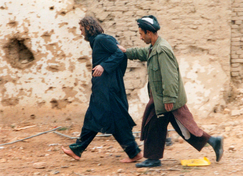 © Reuters. FILE PHOTO: U.S.-born John Walker Lindh is led away by a Northern Alliance soldier after he was captured near Mazar-i-Sharif