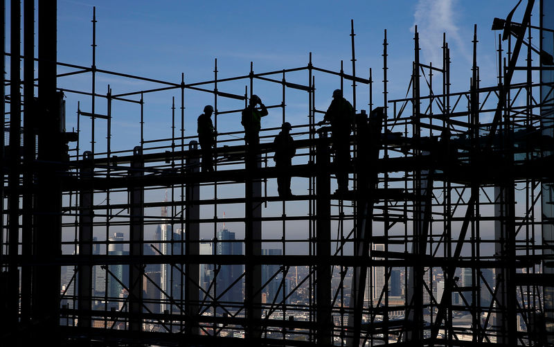 © Reuters. Construction workers are silhouetted while standing on scaffolding at the construction site of the new headquarters of the  ECB during a guided media tour in Frankfurt