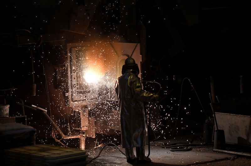 © Reuters. A worker of German steel manufacturer Salzgitter AG stands in front of a furnace at a plant in Salzgitter