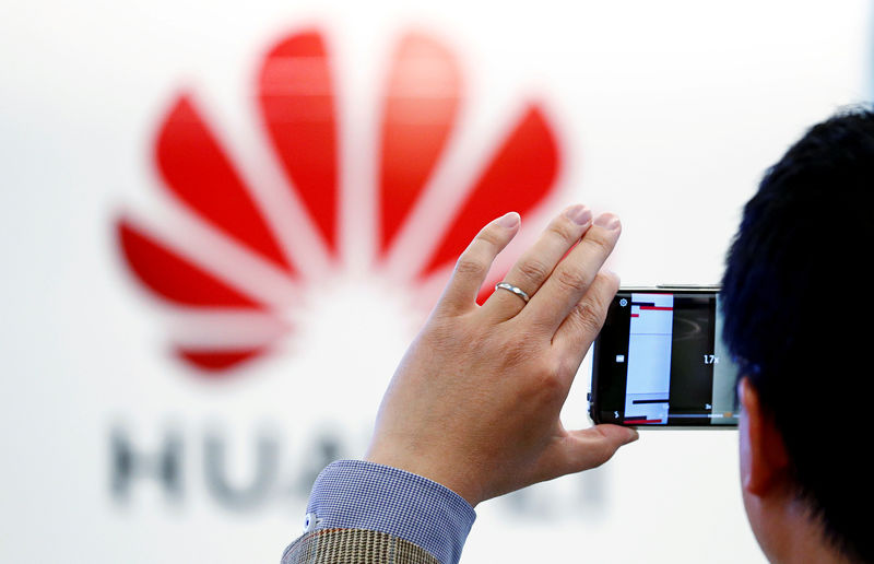 © Reuters. Un hombre toma una fotografía al logo de Huawei en Bruselas, Bélgica.