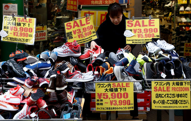 © Reuters. FILE PHOTO: A clerk arranges shoes at a shop in Tokyo
