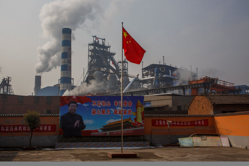 © Reuters. A poster showing Chinese President Xi Jinping is seen in front of the Xinyuan Steel plant in Anyang