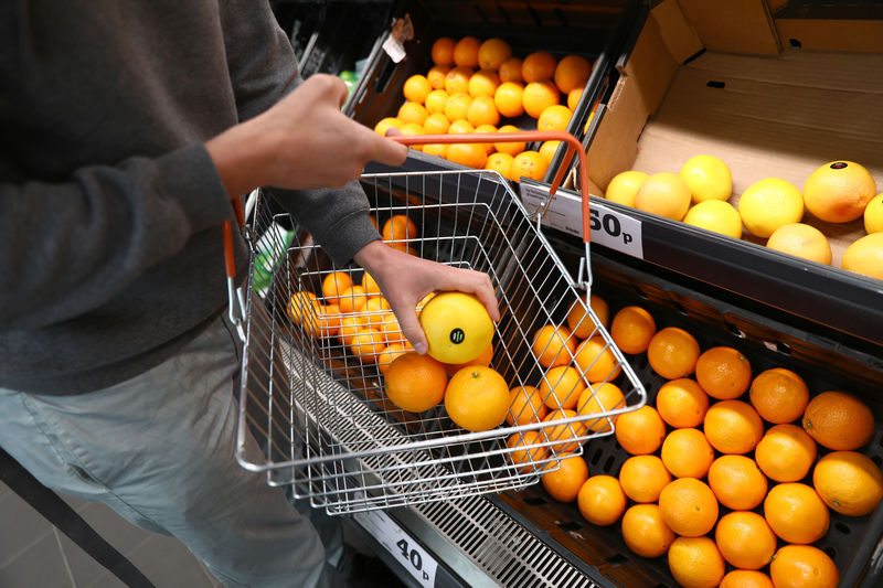 © Reuters. A shopper loads a basket in a supermarket in London