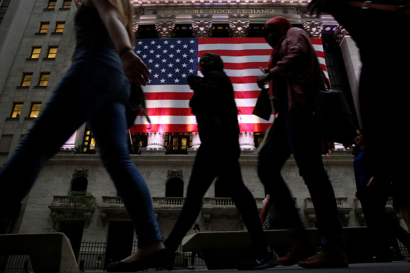 © Reuters. FILE PHOTO: People pass by the NYSE in the financial district  of New York