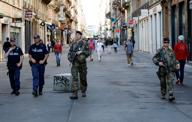© Reuters. Efectivos de la policía y el ejército patrullan las calles durante la búsqueda de persona que dejó una bomba en el centro de Lyon, Francia