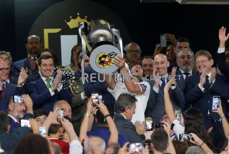 © Reuters. Los jugadores del Valencia celebran su victoria sobre el Barcelona en la Copa del Rey levantando el trofeo, Estadio Benito Villamarín, Sevilla