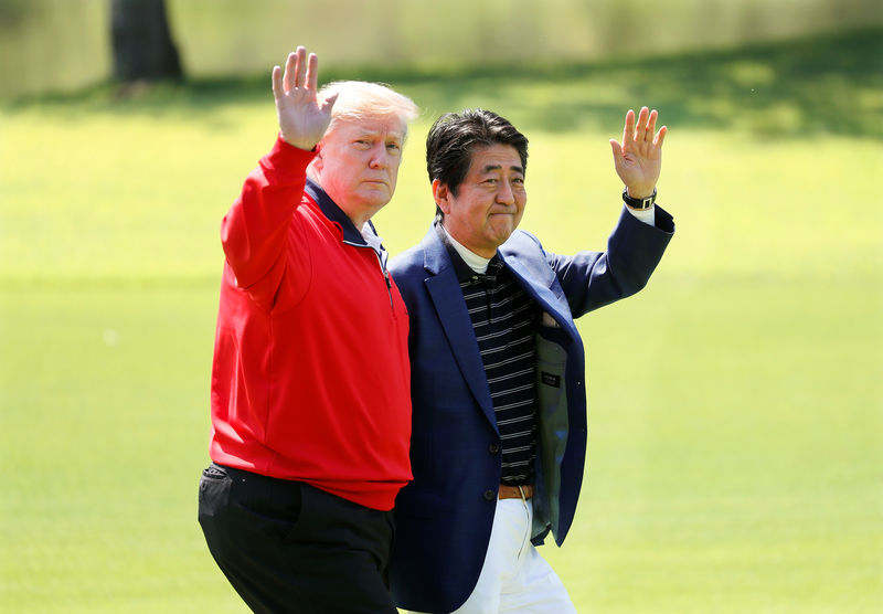 © Reuters. U.S. President Donald Trump and Japanese Prime Minister Shinzo Abe wave on the way to the course to play golf at Mobara Country Club in Mobara, Chiba Prefecture