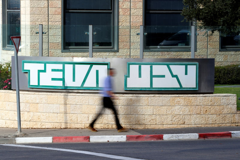 © Reuters. A man walks past the logo of Teva Pharmaceutical Industries at their plant in Jerusalem