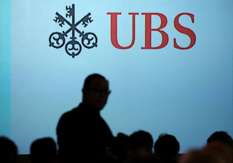 © Reuters. FILE PHOTO: A man walks past a UBS logo projected on a screen in Singapore