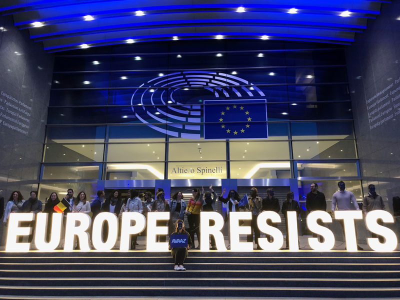© Reuters. Activists display a banner outside the EU Parliament during the European Elections in Brussels
