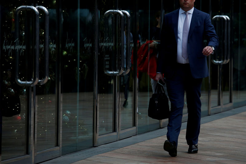 © Reuters. FILE PHOTO: A man walks outside a commercial building at the financial Central district in Hong Kong