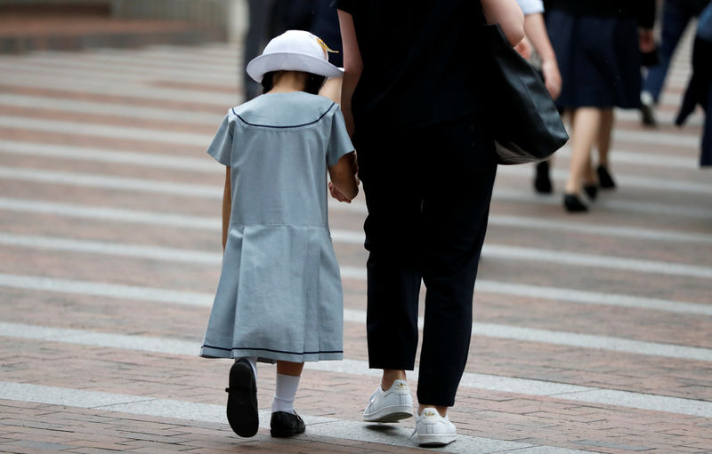 © Reuters. Mãe leva aluna de escola que teve estudantes atacadas por homem armado com uma faca em Kawasaki, no Japão