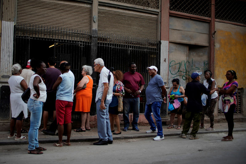 © Reuters. Gente haciendo cola para comprar pollo en una tienda estatal subvencionada, o "bodega", en el centro de La Habana
