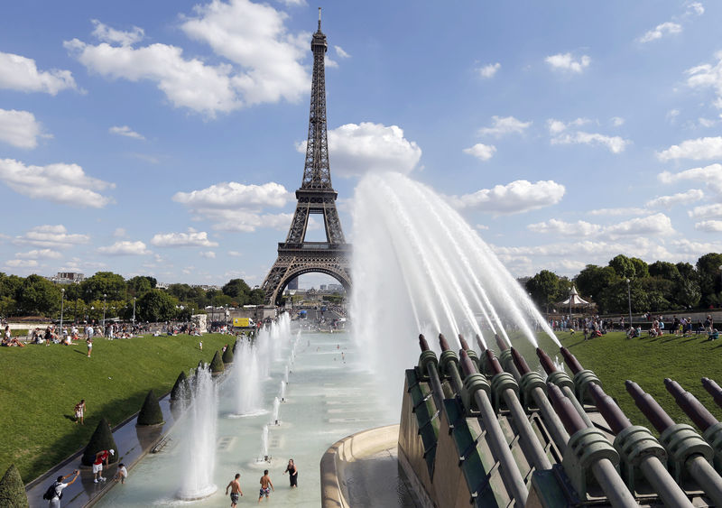 © Reuters. Pessoas se refrescam em fonte de Paris em frente à Torre Eiffel