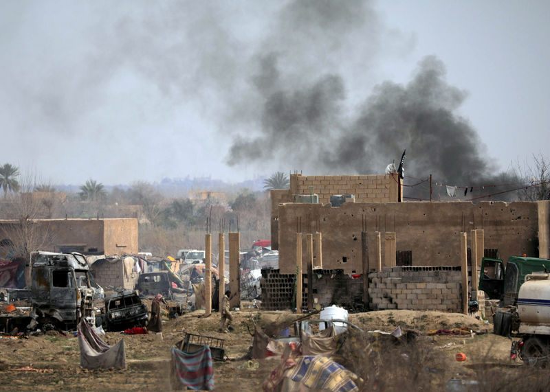 © Reuters. Combatente do Estado Islâmico caminha em vilarejo sírio de Baghouz