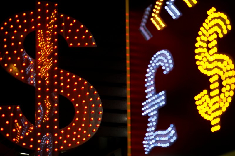 © Reuters. FILE PHOTO: Dollar signs are seen alongside the signs for other currencies at a currency exchange shop in Hong Kong