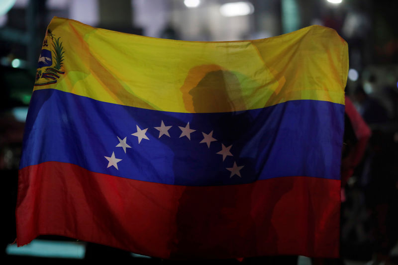 © Reuters. IMAGEN DE ARCHIVO. Una mujer sostiene una bandera de Venezuela durante una vigilia por las víctimas de la violencia en Caracas.