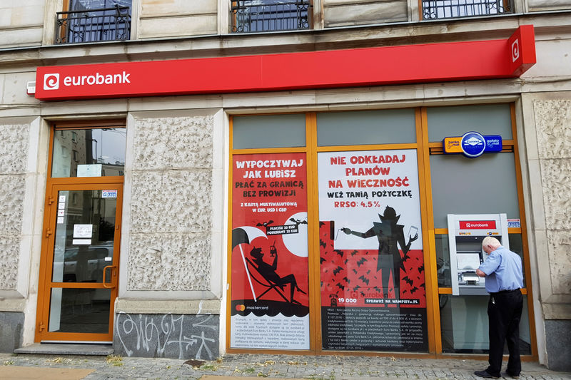 © Reuters. FILE PHOTO: A man operates a cash machine at Societe Generale's Polish unit Eurobank outlet in Warsaw