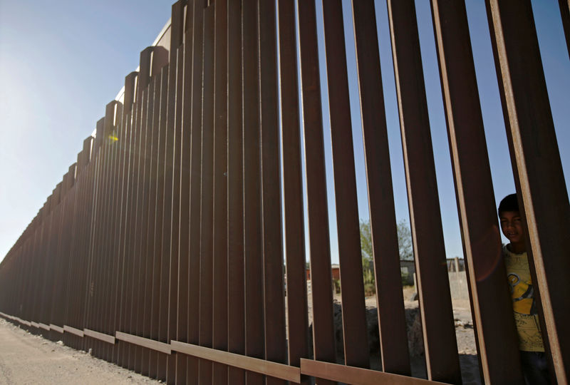 © Reuters. FILE PHOTO: A child looks through the bars of a wall from the side of Ciudad Juarez, Mexico, in this picture taken on the side of El Paso