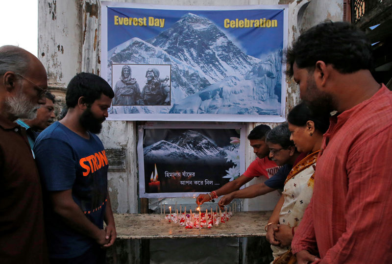 © Reuters. Varias personas encienden velas durante un servicio funerario por los fallecidos a expediciones al monte  Everest en Calcuta