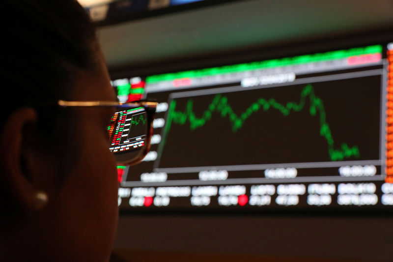 © Reuters. A woman looks at an electronic board showing the graph of the recent fluctuations of market indices on the floor of Brazil's B3 Stock Exchange in Sao Paulo