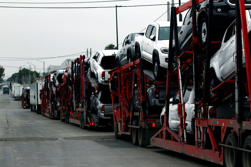 © Reuters. A carrier trailer transports Toyota cars for delivery while queuing at the border customs control to cross into the U.S.