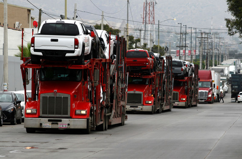 © Reuters. A carrier trailer transports Toyota cars for delivery while queuing at the border customs control to cross into the U.S.