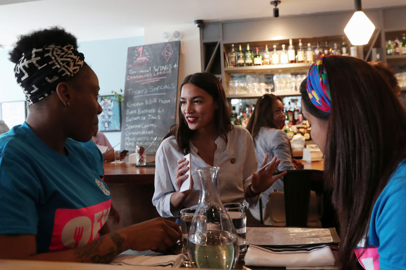 © Reuters. Rep. Alexandria Ocasio-Cortez (D-NY) speaks with people after taking an order in support of One Fair Wage at The Queensboro restaurant in New York