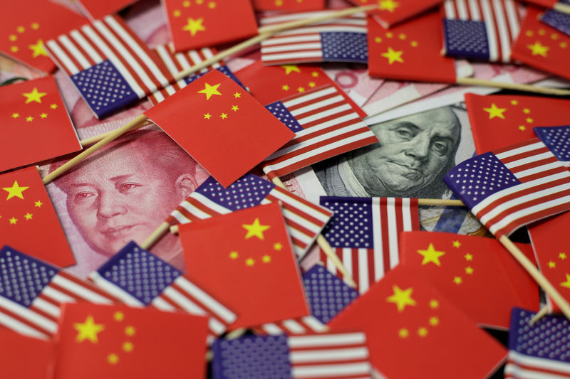 © Reuters. Foto de archivo. Banderas estadounidenses y chinas sobre billetes de dólar y yen.