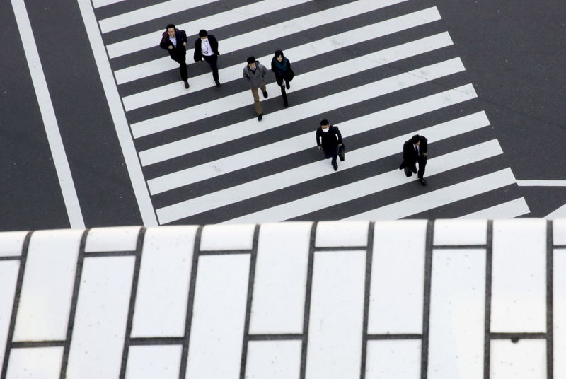 © Reuters. FILE PHOTO: People cross a street in a business district in Tokyo
