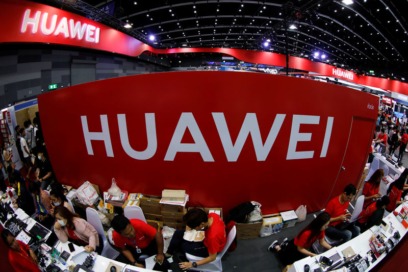 © Reuters. FILE PHOTO: Workers sit at the Huawei stand at the Mobile Expo in Bangkok