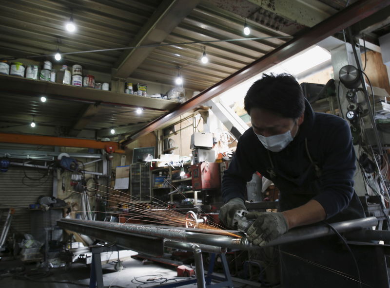 © Reuters. An engineer makes an arm rail for residential buildings inside a metal processing factory at an industrial zone in downtown Tokyo