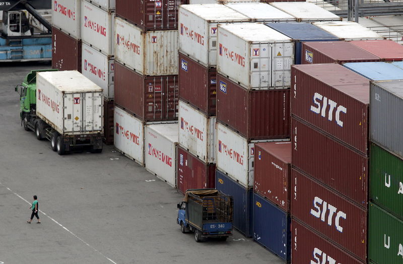 © Reuters. A person walks near containers at Keelung port, northern Taiwan