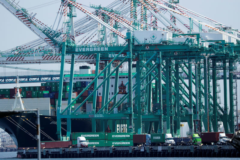 © Reuters. Trucks offload containers from ship at the port of Los Angeles in Los Angeles, California