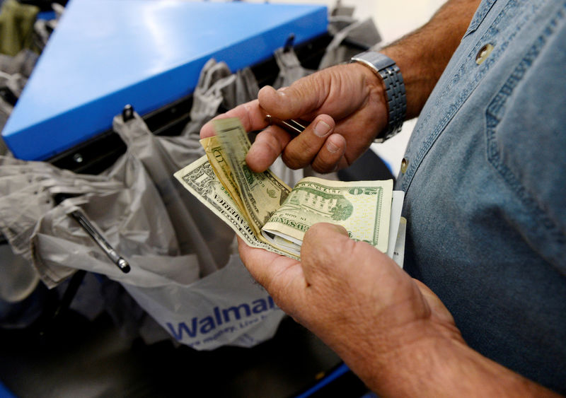 © Reuters. FILE PHOTO: FILE PHOTO: A customer counts his cash at the checkout lane of a Walmart store in the Porter Ranch section of Los Angeles