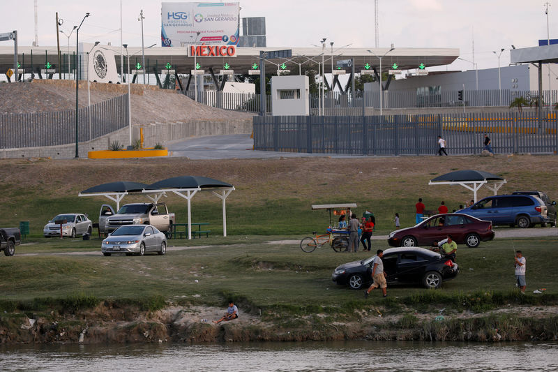 © Reuters. Mexicans enjoy the afternoon on the shore of Rio Bravo near the border, as is seen from Laredo, Texas