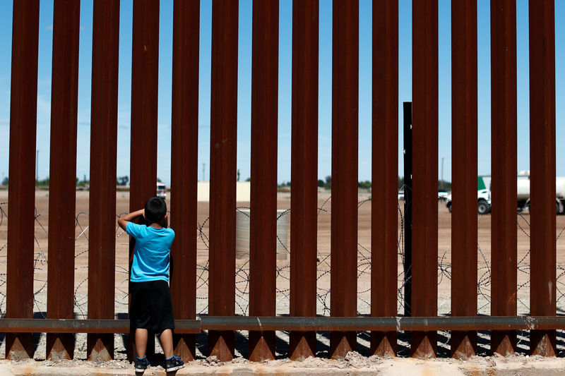 © Reuters. A child looks through the border wall during the visit of U.S. President Donald Trump to Calexico, California, as seen in Mexicali