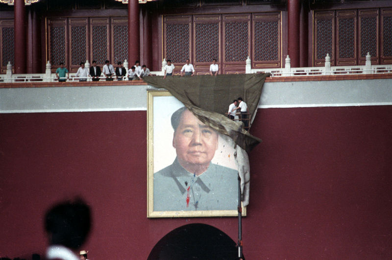 © Reuters. FILE PHOTO: Workmen try to drape the portrait of Mao Zedong in Tiananmen Square in Beijing