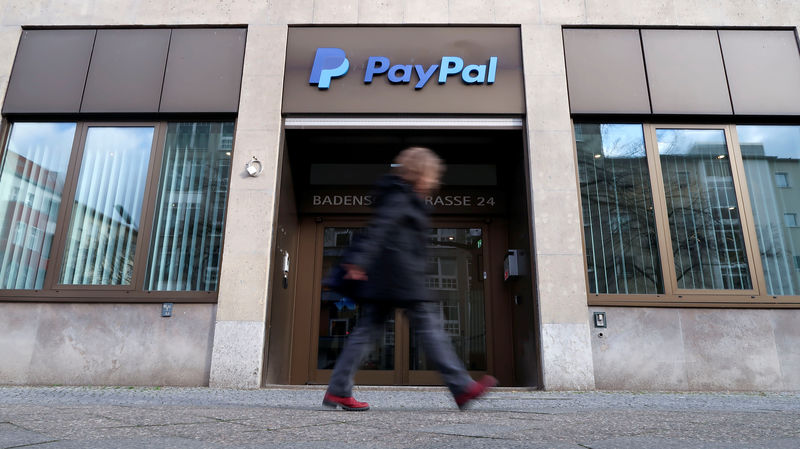 © Reuters. A pedestrian walks past the PayPal logo at an office building in Berlin
