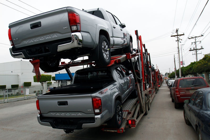 © Reuters. A carrier trailer transports Toyota cars for delivery while queuing at the border customs control to cross into the U.S.