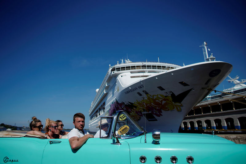 © Reuters. Tourists ride in a vintage car next to a cruise ship docked in Havana