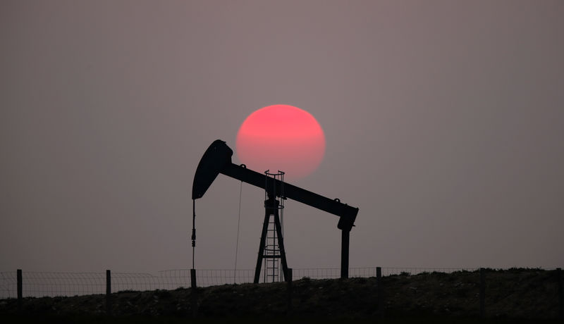 © Reuters. The sun sets behind a pump-jack outside Saint-Fiacre