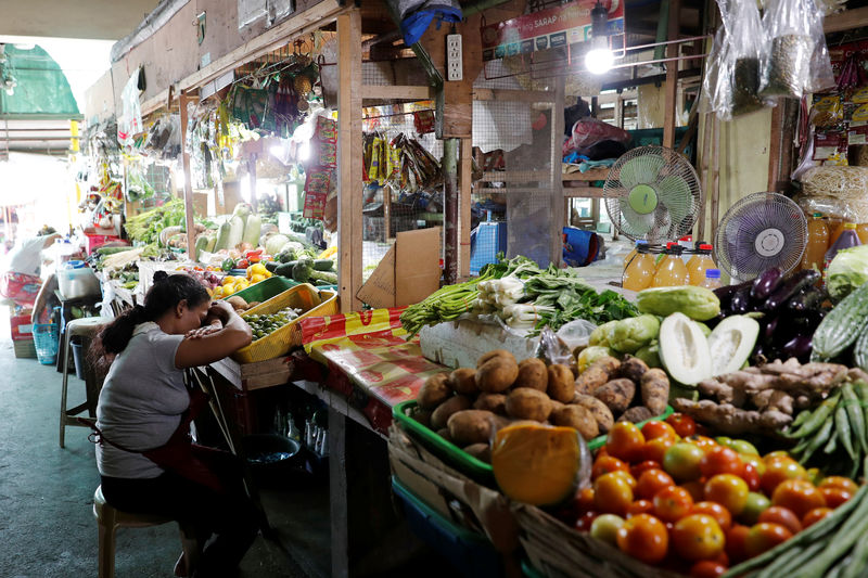 © Reuters. FILE PHOTO: A vendor rests while waiting for customers at a food market in Las Pinas