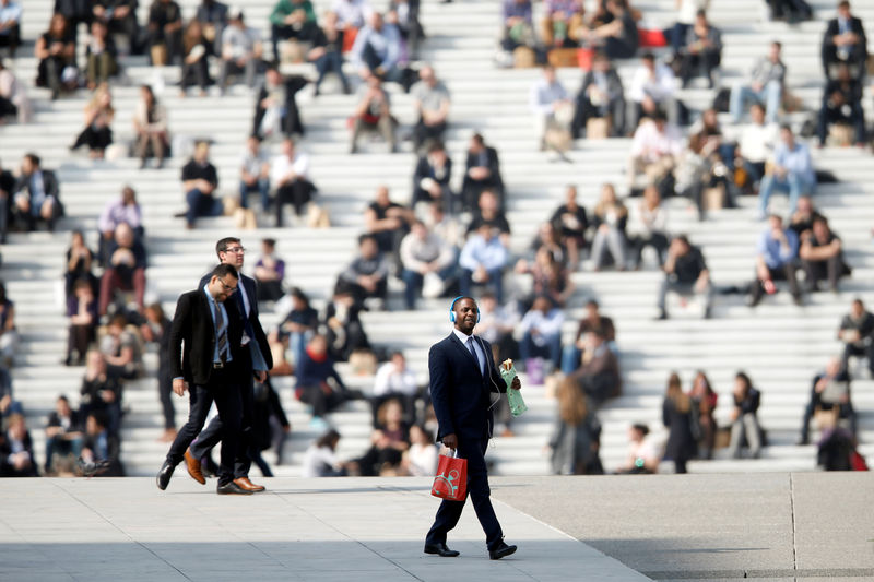 © Reuters. FILE PHOTO: Businessmen enjoy the good weather at lunch time under the Arche de la Defense, in the financial district west of Paris in France