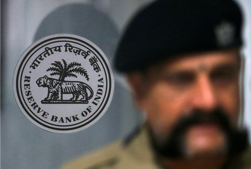 © Reuters. A security guard stands next to the logo of Reserve Bank of India inside its headquarters in Mumbai