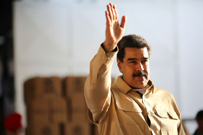 © Reuters. FILE PHOTO: Venezuela's President Nicolas Maduro waves during his visit to a packing center of the CLAP (Local Committees of Supply and Production) program, a Venezuelan government handout of basic food supplies, in Caracas