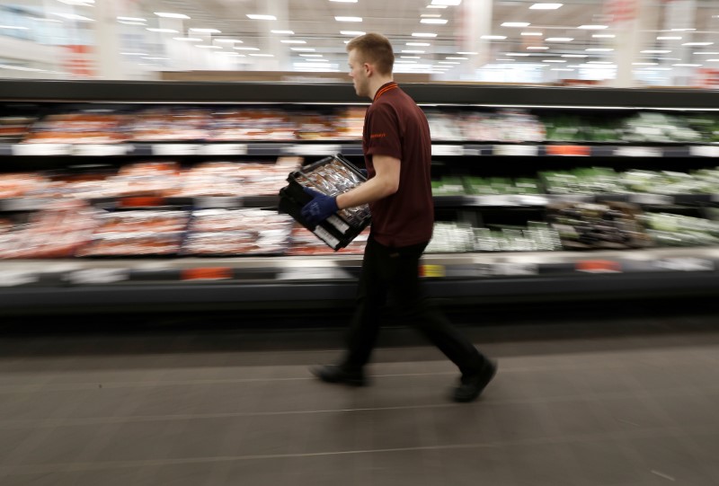 © Reuters. FILE PHOTO: A Sainsbury's worker stacks a vegetable shelf in a store in Redhill